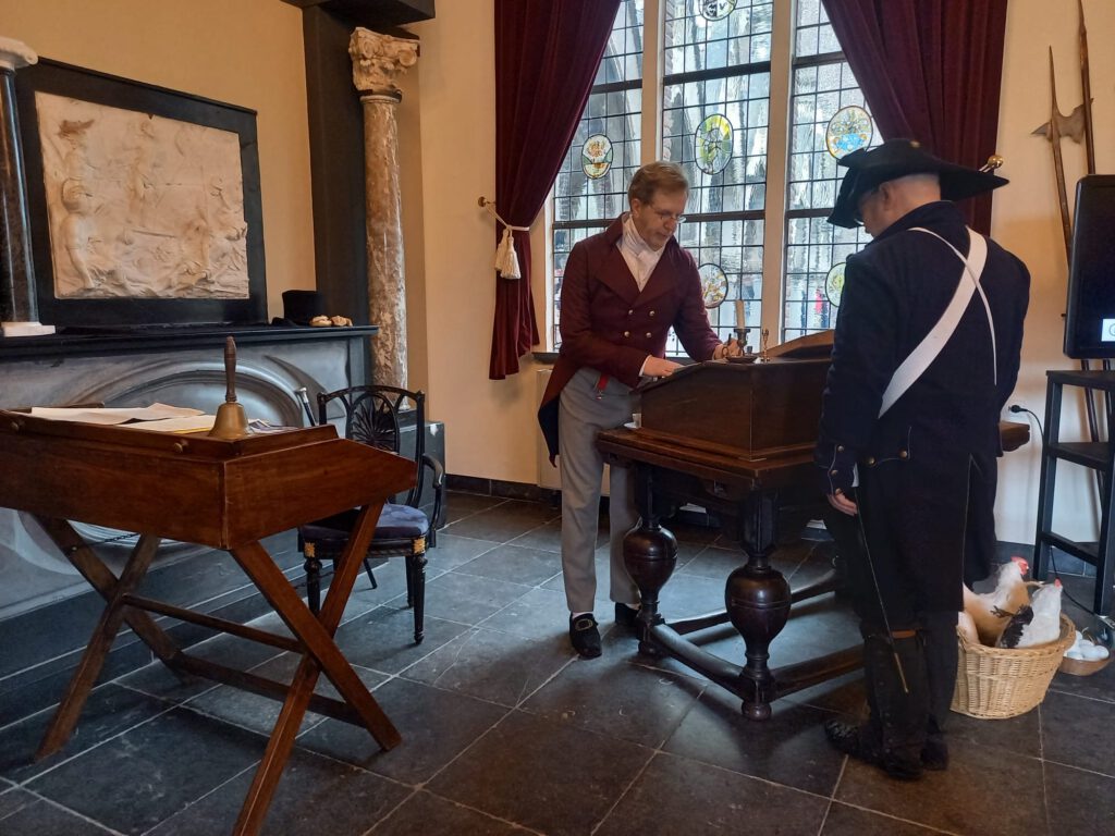 De rentmeester in gesprek met een soldaat in de Wapenkamer van Kasteel Heeswijk